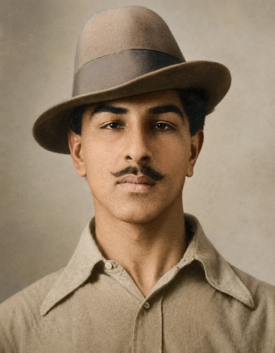 Illustration of Bhagat Singh as a young man in a wide-brimmed felt hat and plain collared shirt, facing the camera.